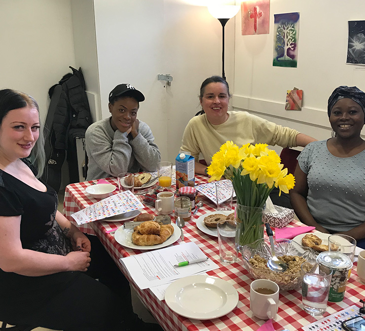 women sitting around a table with yellow flowers and pastries at Kids Matter parenting programme