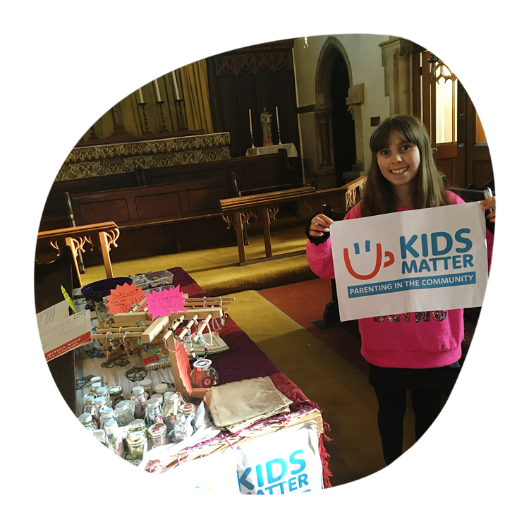 Amelia standing by the stall in a local church raising money for Kids Matter