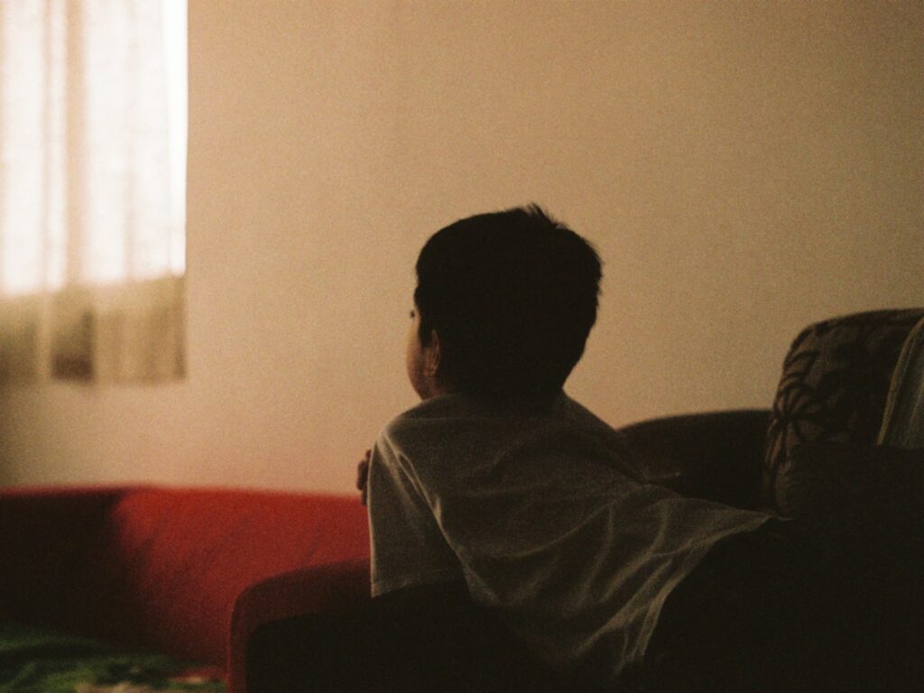 boy resting on a couch looking away from the camera