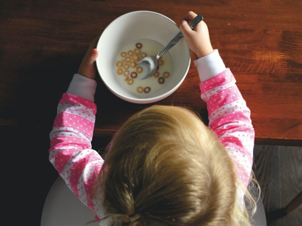 little girl eating Cheerios for breakfast