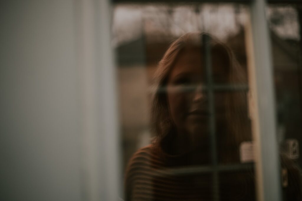 woman's face reflected in window