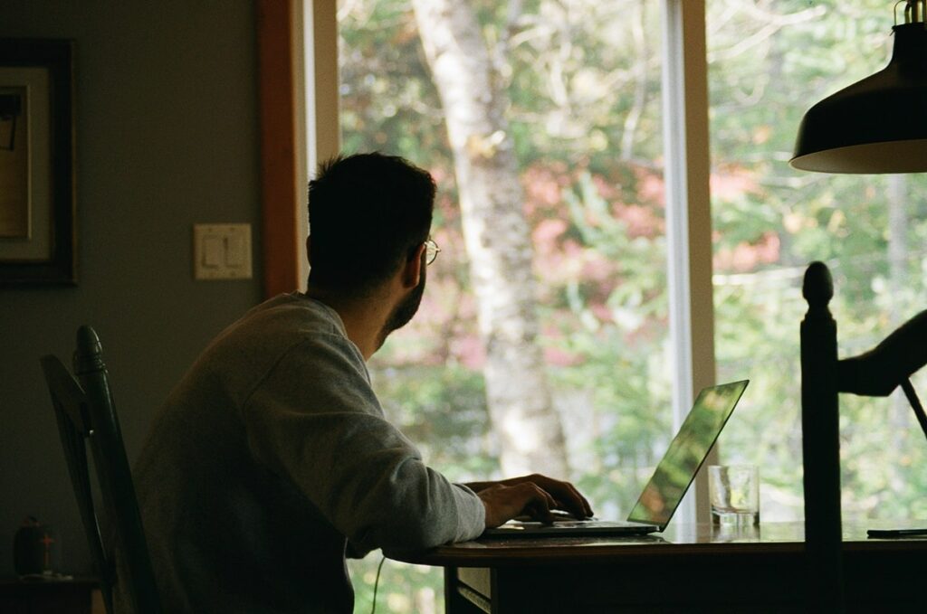man sitting at desk working on laptop