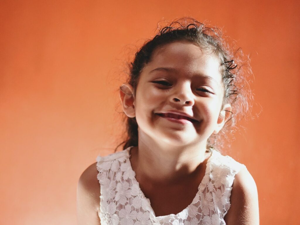 happy smiling girl against orange background