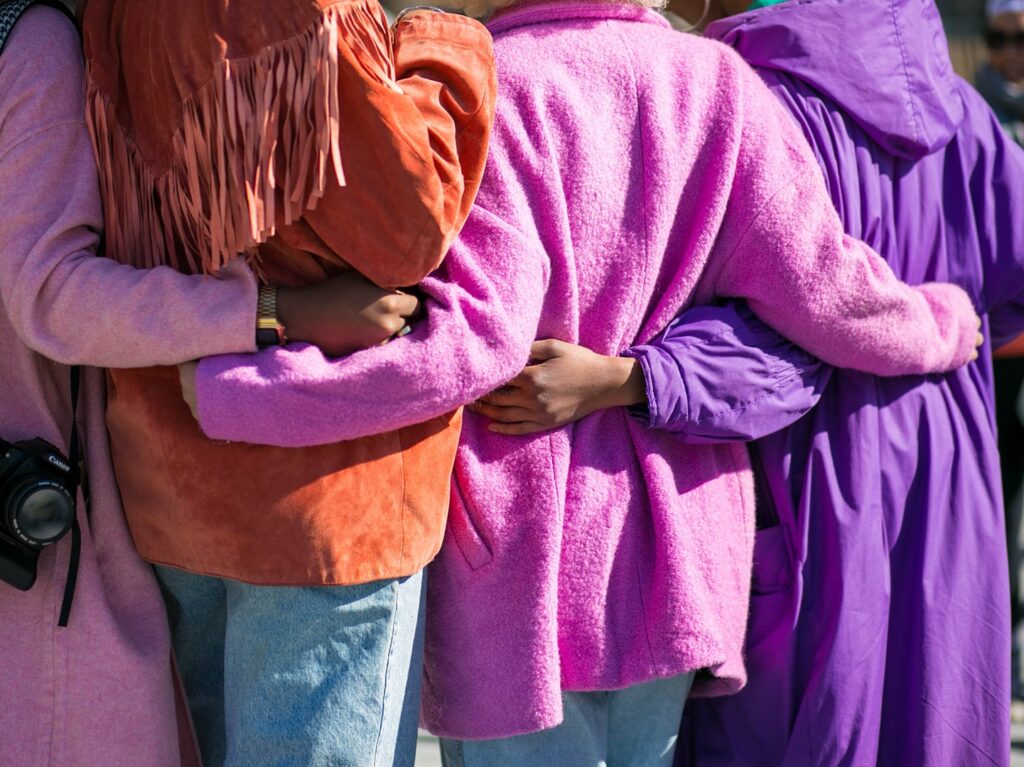 women standing together holding each other around the waist